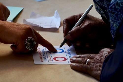 بالصور..موظفة توجه امرأة مسنة بإحدى اللجان للتصويت بـ”نعم”