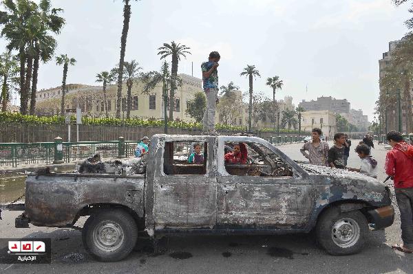 أطفال الشوارع يفككون سيارة شرطة محترقة لبيعها بالتحرير