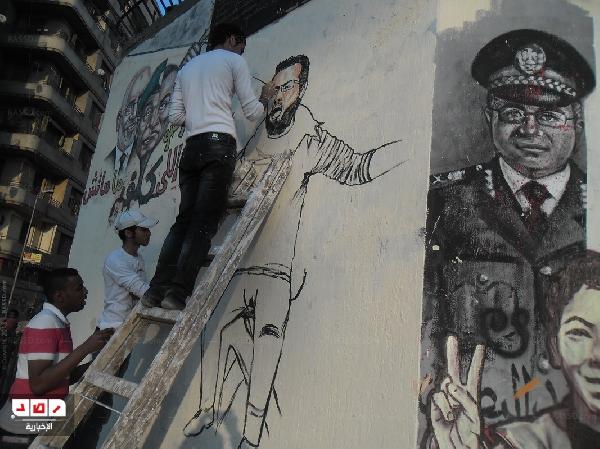 رسوم  “جرافيتى” لمعتقلي 6 ابريل على سور الجامعة الأمريكية