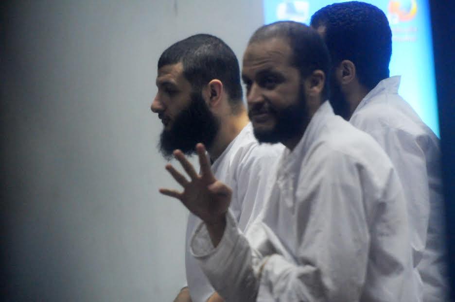 متهمو “التخابر مع قطر” يلوحون بإشارات “رابعة” قبل النطق بالحكم