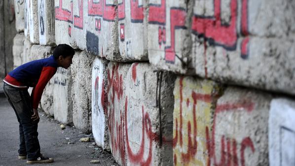 أطفال الشوارع يشعلون النار خلف الجدار العازل بـ “قصر العيني”