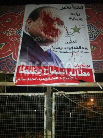 بالصور: تلطيخ صور السيسي بلون “الدم” في طنطا