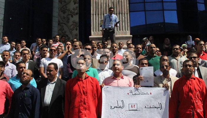 حملة الماجيستير والدكتوراه يتظاهرون بملابس الإعدام أمام نقابة الصحفيين